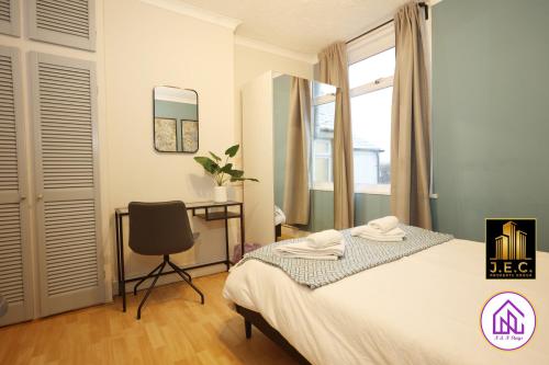 a bedroom with a bed and a desk and a chair at Clodien House, Great Location, Free Parking in Cardiff