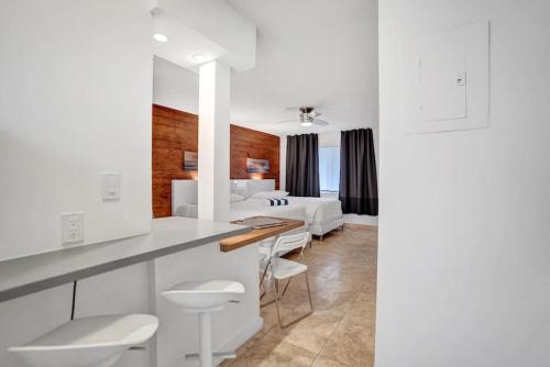 cocina blanca y sala de estar con cama en Waves Beach Town Spacious Studio Apartment For 4 People en Pompano Beach