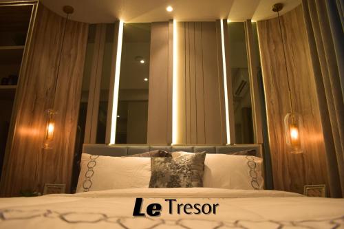 a bedroom with a bed with a large mirror at Le Tresor Benson Apartment at Supermal Pakuwon in Surabaya