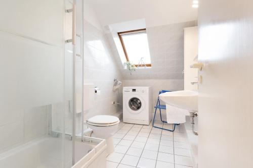 een badkamer met een toilet, een wastafel en een wasmachine bij Wohnpark Heisterbusch Ferienhaus Kamphans in Kellenhusen