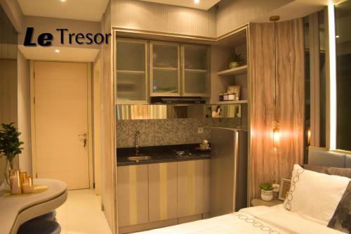 a small kitchen with a sink and a refrigerator at Le Tresor Benson Apartment at Supermal Pakuwon in Surabaya