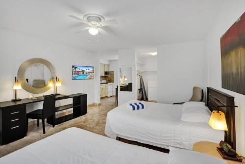 a bedroom with a bed and a desk and a mirror at Waves Beach Town Spacious Studio Apartment For 4 People in Pompano Beach