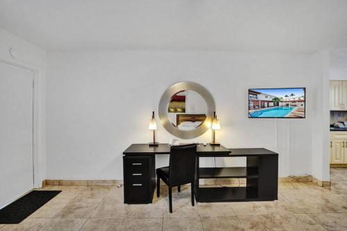a desk with a mirror and a chair in a room at Waves Beach Town Spacious Studio Apartment For 4 People in Pompano Beach