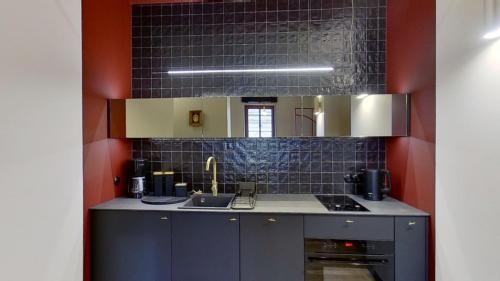 a kitchen with a sink and a stove at Entu Apartamenty Odrzanska in Wrocław