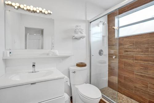 a bathroom with a toilet and a sink and a shower at Waves Beach Town Cozy Studio Apartment in Pompano Beach