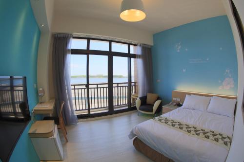 Habitación de hotel con cama y balcón en Luck Bay B&B, en Magong