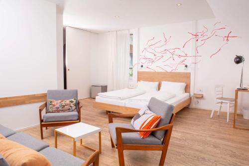ein Wohnzimmer mit einem Bett und 2 Stühlen in der Unterkunft Hotel Tafelfreuden in Oldenburg