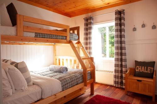 a bedroom with a bunk bed and a window at Bleu Azur 32 night Lakefront Retreat w Hot tub in Saint Adolphe D'Howard