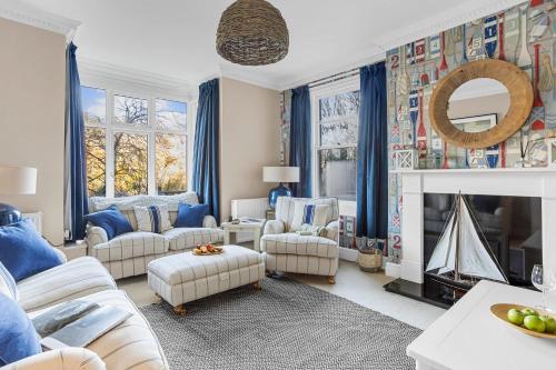 a living room with blue curtains and a fireplace at Homefield - Chic charm with unrivalled river views in Kingswear