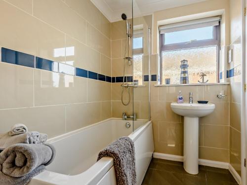 a bathroom with a bath tub and a sink and a bath tub at 2 bed in Sutton-on-Sea 80703 in Sutton on Sea