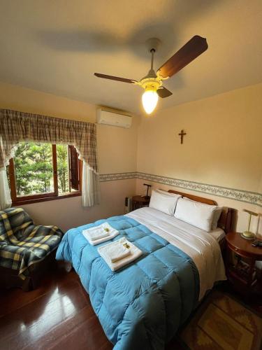 1 dormitorio con 1 cama y ventilador de techo en Apto Retro - 500m da Praça das Flores en Nova Petrópolis