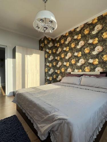 a bedroom with a large bed and a chandelier at Cozy Boutique Apartment in Plovdiv in Plovdiv