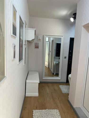 a white room with a mirror and a hallway at Cozy Boutique Apartment in Plovdiv in Plovdiv