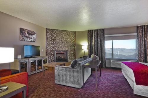 a hotel room with a couch and a bed and a television at Shoshone Rose Casino & Hotel in Lander