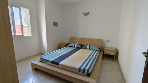 ein Schlafzimmer mit einem Bett in einem Zimmer mit einem Fenster in der Unterkunft Ca Oceano 5 in Santa Maria