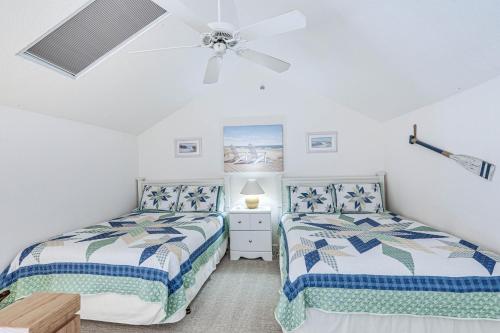 two beds in a bedroom with a ceiling fan at Osage Beach Condo Boat Slip and Pool Access! in Osage Beach