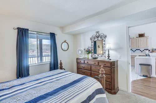 a bedroom with a bed and a dresser and a mirror at Osage Beach Condo Boat Slip and Pool Access! in Osage Beach