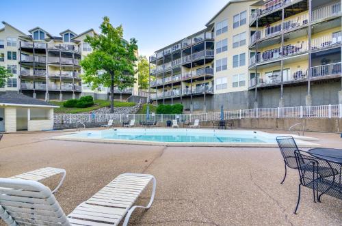 a pool with chairs and a table and a building at Osage Beach Condo Boat Slip and Pool Access! in Osage Beach