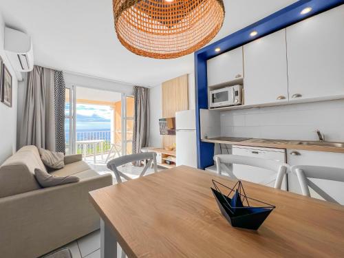 cocina y sala de estar con mesa y sofá en Azure Escape, en Saint-Raphaël