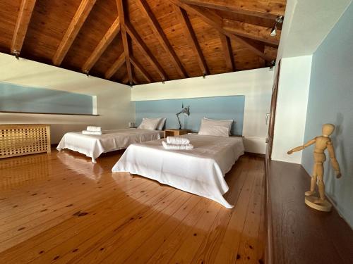 1 dormitorio con 2 camas y suelo de madera en Elia Pilio Villas, en Pelión