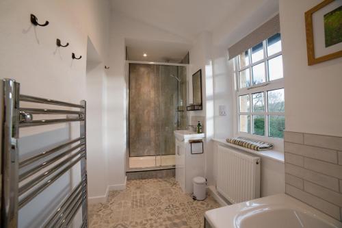 a bathroom with a tub and a sink and a shower at Dales View Cottage in Sedbergh