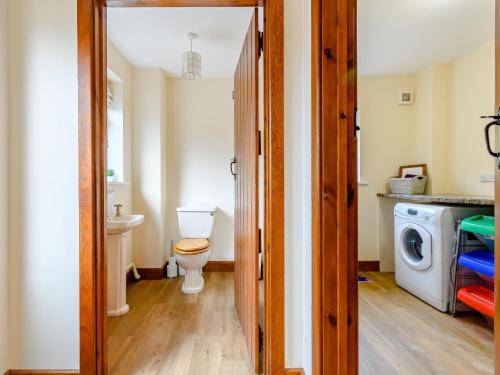 a bathroom with a toilet and a washing machine at 3 bed in Builth Wells 78329 in Crickadarn