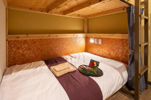 un letto a castello con un piatto di cibo sopra di IKIDANE Cozy Hotel Haneda Airport - Vacation STAY 25834v a Tokyo