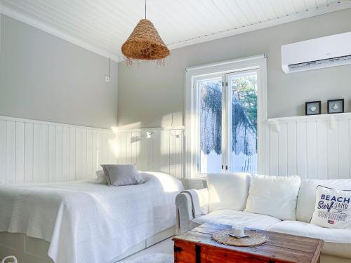 a white bedroom with a bed and a couch at Villa Primavera Apartment in Hanko in Hanko