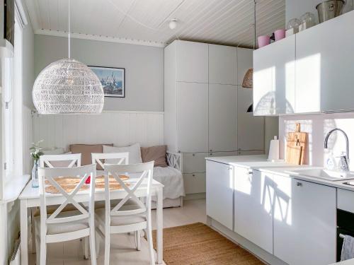 a kitchen with white cabinets and a table and chairs at Villa Primavera Apartment in Hanko in Hanko