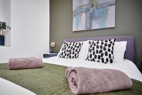 a bedroom with a white bed with black and white pillows at Portstewart Central Loft Apartment in Portstewart