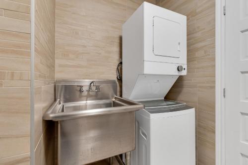 uma pequena cozinha com um lavatório e uma máquina de secar roupa em Lofts de la petite Italie em Montreal