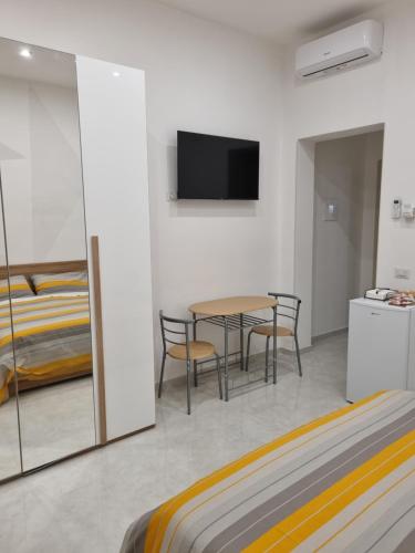 1 dormitorio con mesa, sillas y 1 cama en Locazione turistica adriatico en Bari