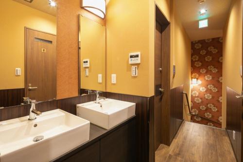 baño con 2 lavabos y espejo grande en IKIDANE Cozy Hotel Haneda Airport - Vacation STAY 25843v, en Tokio