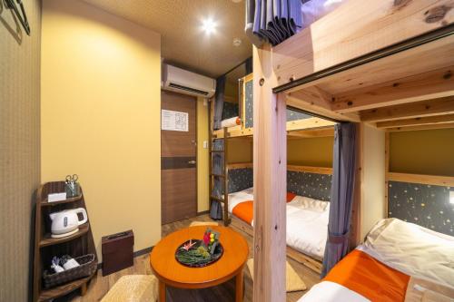 um quarto com 2 beliches e uma mesa em IKIDANE Cozy Hotel Haneda Airport - Vacation STAY 25843v em Tóquio