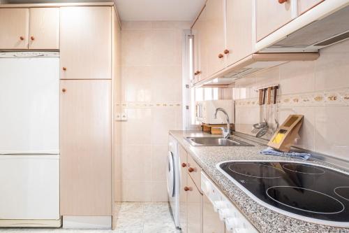 una pequeña cocina con fregadero y nevera. en Edimar 2-3 Apartment Levante Beach, en Benidorm