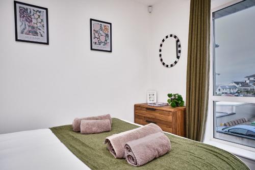 a bedroom with a bed with two pillows and a window at Portstewart Central Loft Apartment in Portstewart