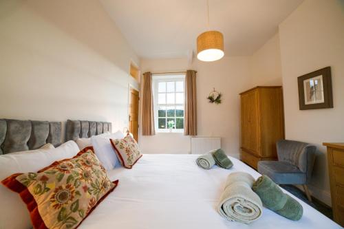 a bedroom with a white bed with pillows and a window at Dales View Cottage in Sedbergh