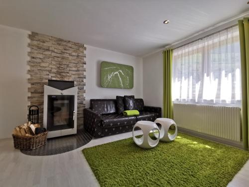 a living room with a black couch and a fireplace at das Alpenblick & Outdoor Lodge Nauders in Nauders