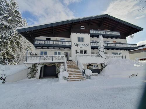 een groot gebouw met sneeuw ervoor bij Boutique Hotel Alpenhof in Sankt Martin am Tennengebirge