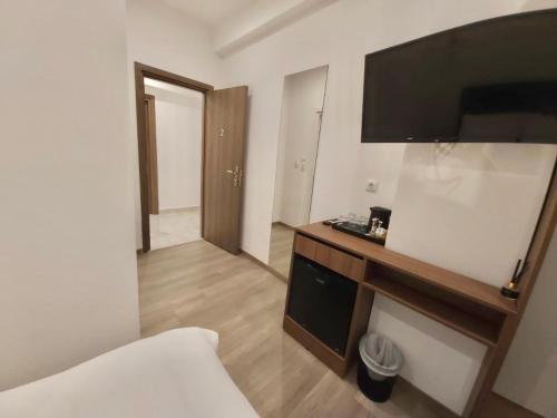 um quarto de hotel com uma cama e uma televisão na parede em Real City Suites Syntagma em Atenas