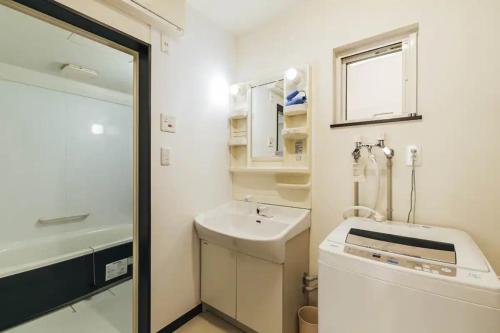 a bathroom with a sink and a washing machine at STAY IN ASAHIBASHI - Vacation STAY 26632v in Asahikawa