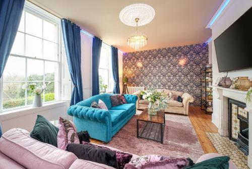 a living room with blue couches and a fireplace at The Steam House - 3 Bedroom Townhouse in Bath by Mint Stays in Bath