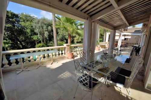 a screened in porch with a glass table and chairs at Villa spa hamman sauna Piscine 9 chambres in Juan-les-Pins