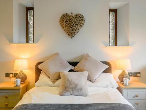 a bedroom with a bed with pillows and a heart on the wall at 3 Bed in Brecon 88249 in Brecon