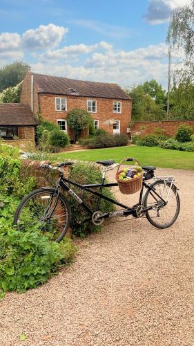a bike with a basket parked in front of a house at Welsh Cottage in Little Marcle
