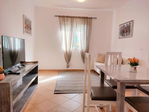 a living room with a table and a dining room at Branco Sea Holiday Apartments in Santa Maria