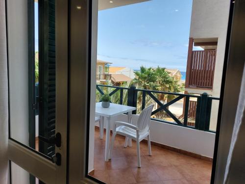 a room with a balcony with a table and chairs at Branco Sea Holiday Apartments in Santa Maria