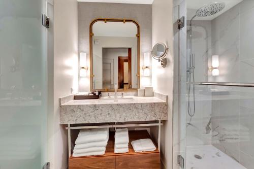 a bathroom with a sink and a mirror at Tideline Palm Beach Ocean Resort and Spa in Palm Beach
