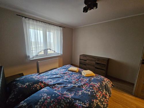 Schlafzimmer mit einem Bett und einem Fenster in der Unterkunft Apartament Nowa Piakowa 2 in Wągrowiec