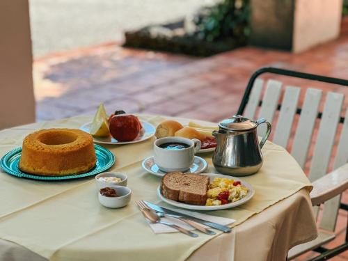 una mesa cubierta con platos de comida y tazas de café en Hotel Cavalinho Branco, en São Francisco de Paula